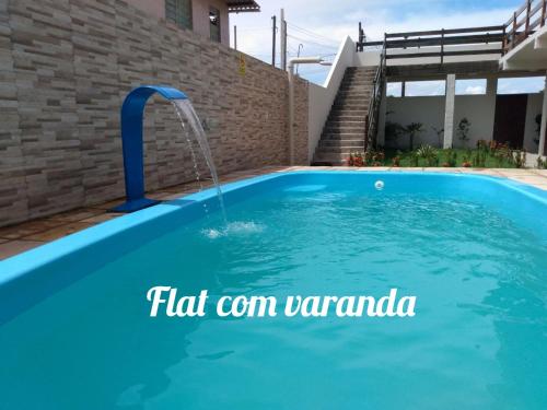 uma piscina com uma fonte de água numa casa em Flat em Porto de Galinhas "com varanda" em Porto de Galinhas