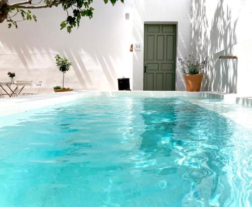- une piscine d'eau bleue en face d'un bâtiment dans l'établissement Casa del Médico Hotel Boutique, à Alcázar de San Juan