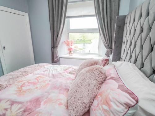 Una cama con una manta floral y una ventana. en 4 Tyne View, en Hexham
