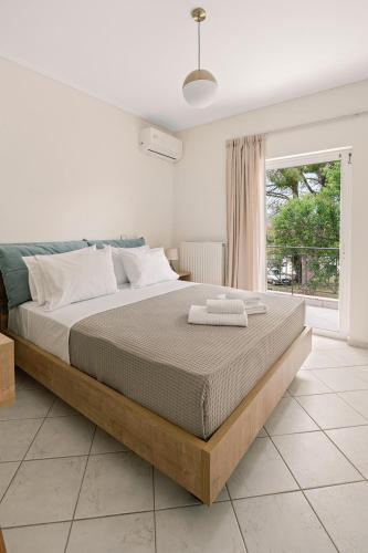 a bedroom with a large bed and a window at Vasilopoulos Residences - Apartments Ioni & Neso, Eliana & Melanthia in Argostoli