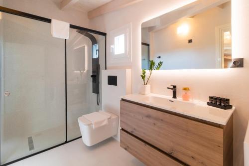 a bathroom with a toilet and a sink and a shower at Melena Premium Suites in Roda