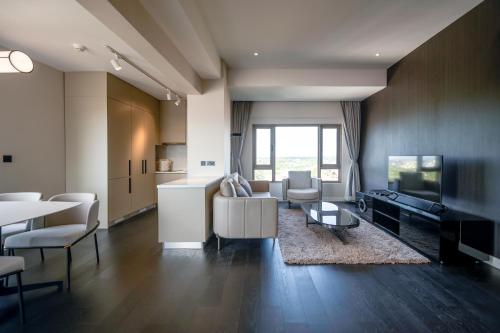 a living room with a couch and a tv and a table at Riverfront Apartments Vientiane in Vientiane