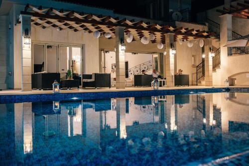 a swimming pool in a building with lights on at Eagles Cliff Villa in Kathikas