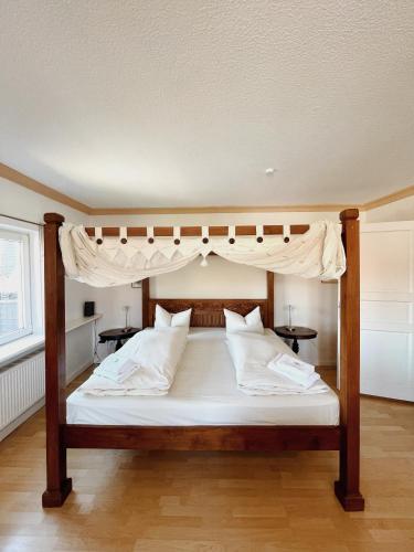 a bedroom with a canopy bed with white pillows at Apartment Josephine in Lübeck