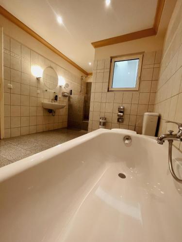 uma grande banheira branca numa casa de banho com uma janela em Apartment Josephine em Lübeck