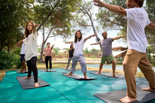a group of people doing yoga on a trampoline at Camping Campo dei Fiori - Glamping4all in Vada