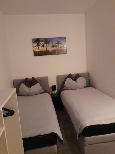 duas camas num quarto com uma fotografia na parede em Berlin - Schönefeld grüne Wohnung em Schönefeld