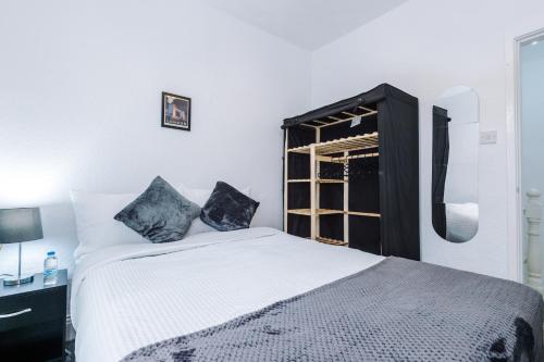 65 inch TV in Modern 2 Bed Hideaway في برادفورد: غرفة نوم بسرير ابيض ونافذة
