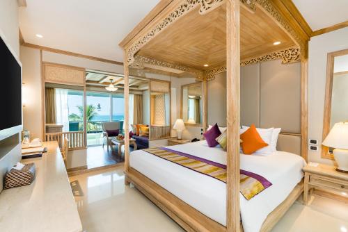 1 dormitorio con cama con dosel y sala de estar. en Royal Cliff Beach Terrace Pattaya en Pattaya South
