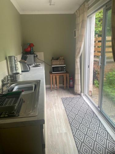 a kitchen with a counter with a sink and a window at Sir Andrew Murray House in Strathyre