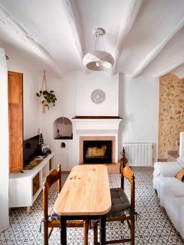 a living room with a table and a fireplace at Ca tia Teresa in Planes