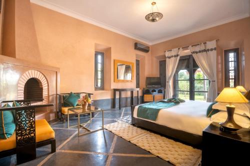 Janat Al Atlas Resort & Spa في مراكش: غرفة نوم مع سرير وغرفة معيشة