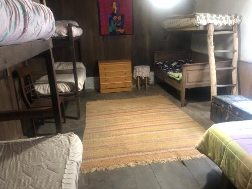 a room with three bunk beds and a rug at Albergue ESCANLAR in Lugo