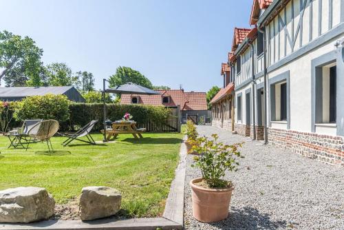 une maison avec une cour avec une table de pique-nique et des rochers dans l'établissement Ensemble de 2 gîtes de charme - 15 personnes, à Sainte-Marguerite