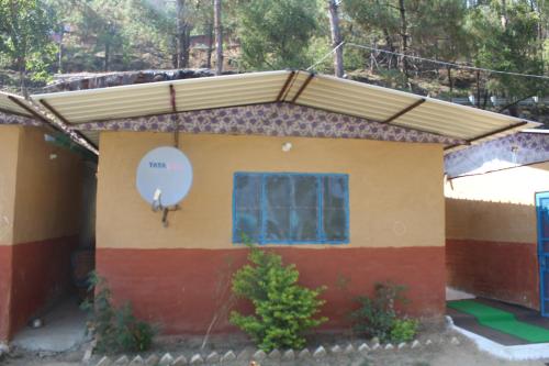 a small house with a window and a roof at 11 Gaon Mudhouse Homestay in Lansdowne