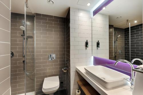 a bathroom with a sink and a shower and a toilet at Premier Inn Frankfurt Westend in Frankfurt