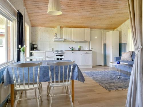 a kitchen and living room with a table and chairs at Strandbergs Stugor in Mariehamn