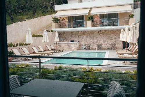 a view of a swimming pool with chairs and umbrellas at Liberte Maisonettes in Parga