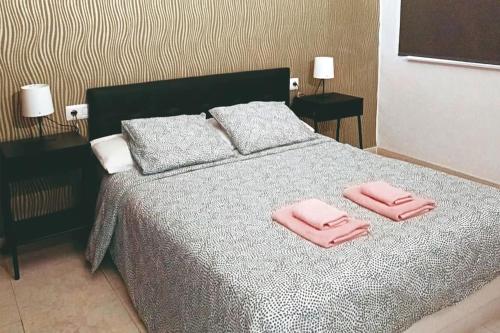 a bedroom with a bed with two pink towels on it at Apartamentos Carrillo 5 in Santa Cruz de Tenerife