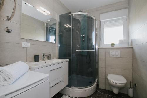 a bathroom with a shower and a toilet and a sink at Royal Blue House 2 in Kaštela