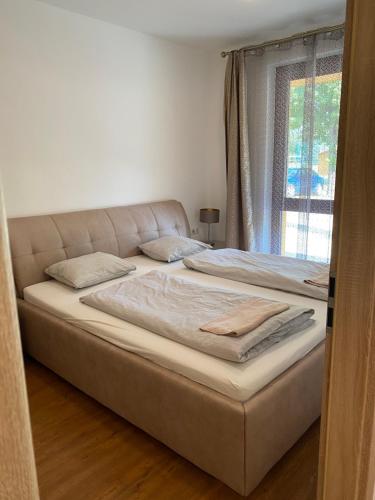 two large beds in a room with a window at Móló Apartmanház in Balatonszemes