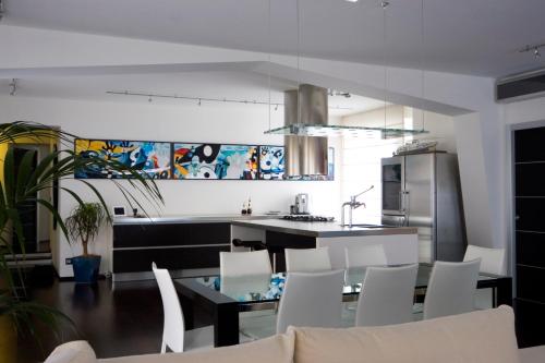 cocina con mesa de comedor y sillas blancas en Marvel House - By My Home In Como en Como