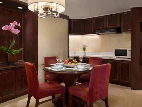 a dining room with a table and chairs and a kitchen at Shangri-La Kuala Lumpur in Kuala Lumpur