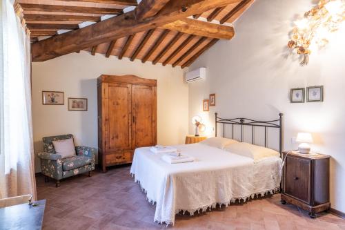 Lupompesi的住宿－Appartamenti le Ginestre，一间卧室配有一张床和一把椅子