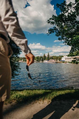 a person throwing a frisbee in front of a lake at OREA Resort Santon Brno in Brno