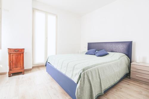 a bedroom with a bed and a nightstand with a blue bedspread at La Terrazza di Roberta in Colonno