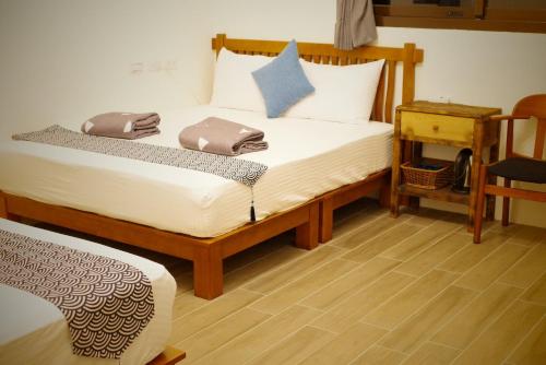 1 dormitorio con 2 camas individuales y 1 silla en 鰆宿民宿, en Dayin