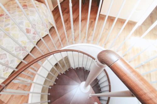 a wooden spiral staircase with a wooden rail at La Terrazza di Roberta in Colonno