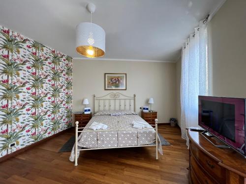 a bedroom with a bed and a flat screen tv at House Sturla by Holiday World in Genova