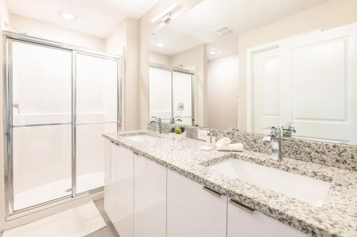 La salle de bains est pourvue de 2 lavabos et d'une douche. dans l'établissement Magical Disney Vacation Home - 5 bedrooms, à Kissimmee
