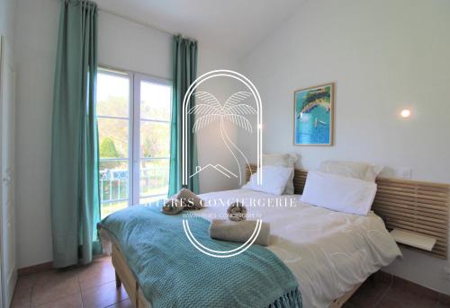 um quarto com uma cama e uma grande janela em Le Hameau de la pinède-Mas 3 étoiles - T3 piscine Clim Parking 100m plage By HC em Hyères