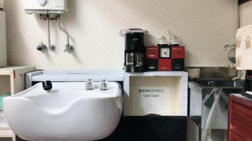 een badkamer met een witte wastafel in een kamer bij Guest House Salt Beach in Yokkaichi