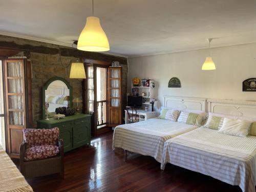 a bedroom with two beds and a chair at Casa Rustica Con Porche in Bostronizo