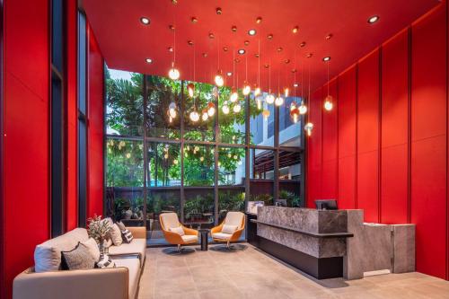 a lobby of a building with red walls and chairs at Best Western Ratchada Hotel in Bangkok