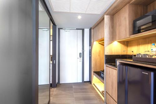 a kitchen with wooden cabinets and a glass door at Best Western Ratchada Hotel in Bangkok
