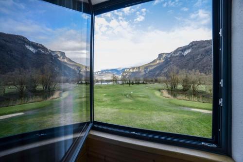 a window with a view of a golf course at Domaine de Charmeil in Saint-Quentin-sur-Isère