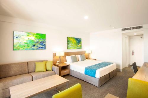 シドニーにあるメトロ アスパイア ホテル シドニーのベッドとソファ付きのホテルルーム