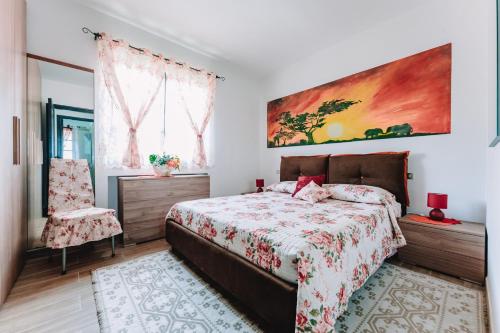 um quarto com uma cama e um quadro na parede em Villa grazia em Capitana