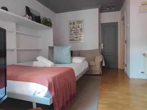 a bedroom with a bed and a couch at Apartamento Jardín de San Feliz / Fontán in Oviedo