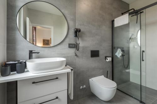 een badkamer met een wastafel, een toilet en een spiegel bij House on first floor 2258 in Pula