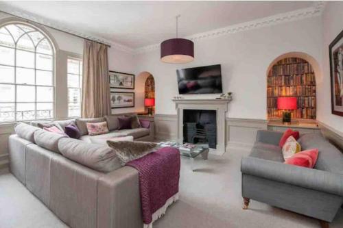 a living room with a couch and a fireplace at No 15 St James’s Townhouse in Bath