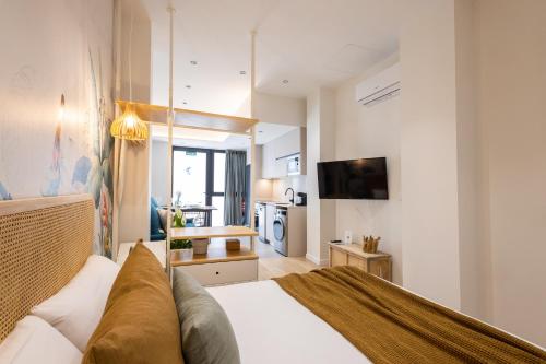a bedroom with a white bed and a kitchen at FLORIT FLATS - The Green Apartments in Valencia