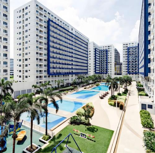 ein Luftblick auf ein Resort mit einem Pool und Palmen in der Unterkunft Reese @ Sea Residences Manila in Manila