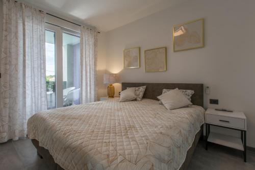 een slaapkamer met een groot bed en een raam bij House on first floor 2258 in Pula