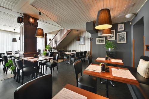 a restaurant with tables and chairs and a staircase at City Hotel Morris in Česká Lípa