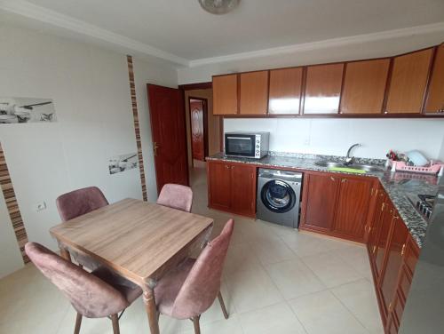 a kitchen with a table and chairs and a microwave at Appartement familial au centre de Nador Ville in Nador